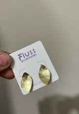 Par de aros dorados con forma de hoja y textura martillada.