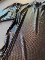 Polera de manga larga con acabado brillante color peltre, cuello alto y frunces sutiles en los hombros.