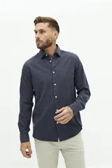 Camisa de manga larga lisa con cuello clásico y cierre frontal de botones. Presenta un ajuste regular y un pequeño logo bordado en el pecho.