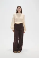Pantalon de jean de corte ancho y tiro medio, en color natural, con cierre frontal y bolsillos laterales.