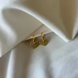 Aros colgantes dorados con forma de corazón cubiertos de strass.