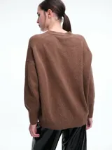 Cardigan de punto color marrón con textura jaspeada, escote en V, cierre frontal con botones y diseño de hombros caídos.