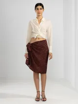 Camisa negra de manga larga con lazo en la cintura y botones nacarados. Confeccionada en 100% algodón y detalle de Polonio en cobre.