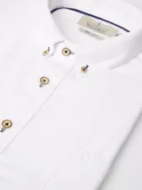 Camisa de corte clásico confeccionada en tejido Oxford de algodón, con cuello abotonado, manga larga y bolsillo frontal en el pecho.
