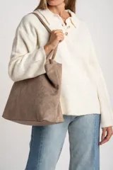 Sweater de tejido de punto color blanco roto o crema, con textura jaspeada. Presenta cuello polo y un escote con tres botones nacarados. El calce es holgado (oversize) y tiene mangas largas.