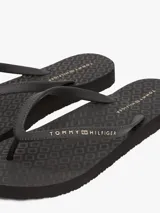 Ojotas Tommy Hilfiger negras con logo texturizado en la tira.