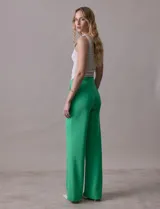 Pantalón naranja de crepe elastizado, corte recto, con bolsillos delanteros y apliques de botones metálicos.