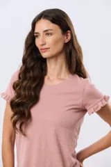 Remera de algodón color verde menta, con escote redondo y mangas corta con detalles de volados sutiles en los puños.