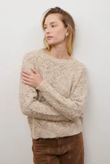 Buzo de punto con cuello redondo, manga larga y textura jaspeada en tonos beige y crema.