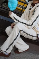 Pantalon negro de estilo deportivo con bolsillos laterales tipo cargo y una banda lateral con inscripciones. Presenta un corte cómodo y relajado.