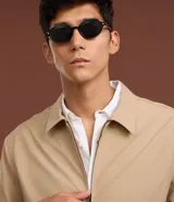 Campera de sarga color beige con cuello inglés, cierre frontal de cremallera, mangas largas y bolsillos laterales. Diseño minimalista y versátil con forro interior.