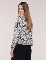Camperita liviana de silueta entallada y largo a la cintura, con cuello camisero, cierre frontal de botones, mangas largas y bolsillos con solapa en el pecho. Presenta estampado animal print.