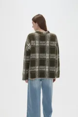 Sweater de punto jacquard con diseño a cuadros en tonos beige y bordó, de corte holgado, cuello redondo y mangas largas.
