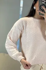 Buzo de tejido chenille con textura en relieve, cuello redondo y mangas largas con puños ajustados.