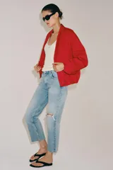 Jeans de tiro medio y corte bootcut cropped de Zara Woman Collection. Confeccionados en denim de efecto lavado en color celeste, presentan diseño de cinco bolsillos, trabillas para cinto, detalle de rotura en la rodilla izquierda y bajo evasé sin costuras. Cierre frontal con cremallera y botón metálico.