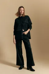 Sobrecamisa de efecto engomado en color negro, con textura lavada, cuello clásico, cierre frontal con botones a tono y bolsillos frontales con solapa.
