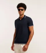 Polo de hombre marca Marfinno, confeccionada en tejido de media malla con textura rayada. Presenta cuello polo con botones y mangas cortas con terminaciones en rib con detalles contrastantes.
