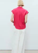 Camisa sin mangas de lyocell color fucsia, con cuello camisero y cierre frontal de botones.