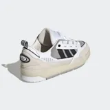 Championes Adidas Adi2000, color blanco con detalles en gris, beige y negro. Confeccionados con exterior de cuero y suela de caucho, inspirados en el estilo skate de principios de los 2000.