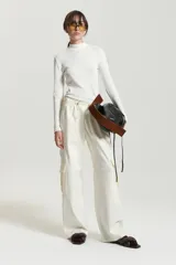 Pantalón babucha color crudo de gabardina con elástico en la cintura, cordón ajustable tipo zapatilla, bolsillos plaque y bolsillos cargo grandes en el delantero.