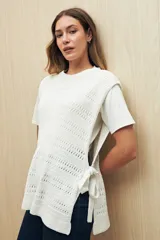 Chaleco de algodón tejido con punto calado, color blanco, sin mangas y con lazos ajustables en los laterales.