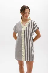 Vestido corto con rayas verticales y horizontales en tonos grises y blancos, con volados color lima en el escote y cierre frontal con botones.