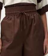 Short runner de tiro medio marca Marfinno, confeccionado en sarga de algodón color marrón. Posee cintura elástica con lazo de ajuste, bolsillos delanteros tipo cargo y diseño holgado.
