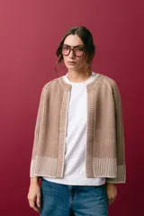 Saco tejido de punto con cuello a la base y manga larga, de diseño reversible y corte recto. Presenta un acabado bicolor que genera un efecto visual de contraste en los bordes y puños.