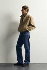 Jeans de denim azul oscuro sin lavados, corte recto con raya frontal planchada, tiro medio, cinco bolsillos y cierre frontal de botonadura. Colección especial Aaron Levine x Zara.