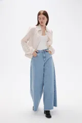 Camisa de algodón con estampado de rayas verticales finas en tonos beige y blanco, cuello clásico, cierre frontal con botones y mangas largas con puños anchos estructurados.