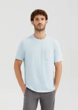 Camiseta de manga corta color celeste, con cuello redondo y bolsillo frontal en el pecho.