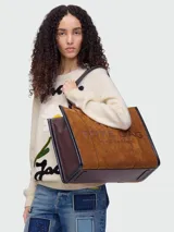 Bolso tote grande Marc Jacobs, modelo The Suede Leather Blocked Large Tote. Cuerpo principal de gamuza color camel con texto en relieve y detalles laterales y base en cuero marrón oscuro.