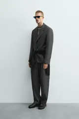 Pantalón de corte relaxed fit confeccionado en tejido 100% lino. Presenta cintura con cierre de cremallera y botón, pliegues frontales, bolsillos laterales y bolsillos traseros de vivo.