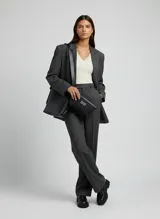 Bolso tipo tote bag negro de efecto cuero con cierre magnético y placa decorativa frontal. Incluye un neceser negro desmontable con cierre.