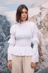 Pantalon tejido de punto en color blanco, de corte recto y holgado, con cintura elástica y cordón ajustable. Presenta una textura acanalada y terminación con volados sutiles en la botamanga.