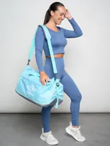 Bolso deportivo Umbro color celeste con detalles en gris y logo estampado en blanco.