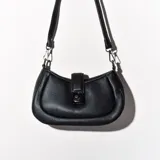 Bandolera negra de cuero sintético con correa fina regulable y cierre con broche metálico.