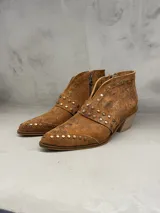 Bota corta de cuero color tabaco, con punta fina, cierre lateral y apliques de tachas doradas.