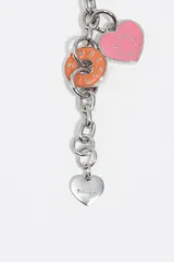 Pulsera de cadena metálica plateada con cierre de mosquetón. Presenta múltiples dijes colgantes en forma de corazón y discos circulares esmaltados en colores rosado, naranja, amarillo, verde y bordó, con el logo de la marca grabado en cada pieza.