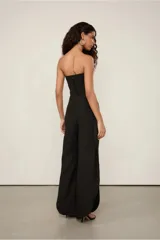 Pantalón negro de crepe sin elasticidad, de calce suelto al cuerpo, con cintura alta, largo completo y aberturas laterales. Cierra mediante botón.