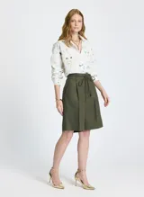 Bermuda verde oliva de lino, con corte entallado, cinturilla con trabillas, cierre de cremallera frontal con corchetes, pliegues delanteros, bolsillos de parche y un cordón a juego.