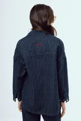 Camisa de denim de corte oversize, color celeste, con bolsillos frontales con solapa y botones metálicos.
