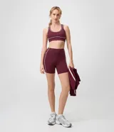 Bermuda deportiva femenina de tiro alto en color bordó, con calce ajustado y líneas contrastantes en los laterales.