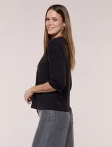 Buzo de calce relajado color negro, confeccionado en modal con cuello redondo clásico, mangas tres cuartos de hombros caídos con puño y ruedo recto.