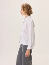 Camisa de corte femenino y sofisticado, con cuello redondo, manga larga y cierre frontal de botones. Confeccionada 100% en algodón.