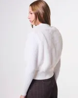 Campera de mujer con diseño híbrido, combinando cuerpo de símil piel de pelo corto y mangas, cuello y pretina en tejido de punto rib acanalado. Presenta cuello alto, cierre frontal metálico y corte a la cadera.