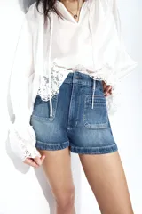 Short de denim azul de tiro alto, confeccionado en algodón levemente elástico con bolsillos delanteros de parche.