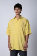 Camisa de manga corta con corte oversize, confeccionada en fibrana premium, con cuello clásico y cierre frontal de botones.