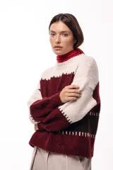 Sweater de punto con diseño de bloques de color en tonos beige, bordó y marrón. Presenta cuello redondo, mangas largas amplias y un calce relajado.