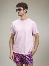 Camiseta de manga corta color rosa pálido, con cuello redondo y un bolsillo simple en el pecho.